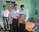 Phó Chủ tịch Thường trực UBND tỉnh Nguyễn Văn Sơn tặng quà của tỉnh cho ông Vương Xuân Cương thương binh hạng 1/4 tại xã Bản Máy.