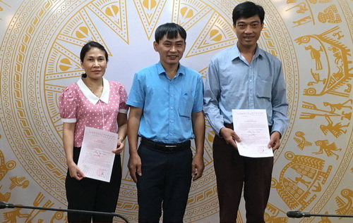 Đồng chí Phạm Minh Tuấn, Bí thư Chi bộ Thông tin - Công báo trao Quyết định Đảng viên chính thức cho đảng viên Nông Thị Thúy Liễu và Đinh Trường Huy.